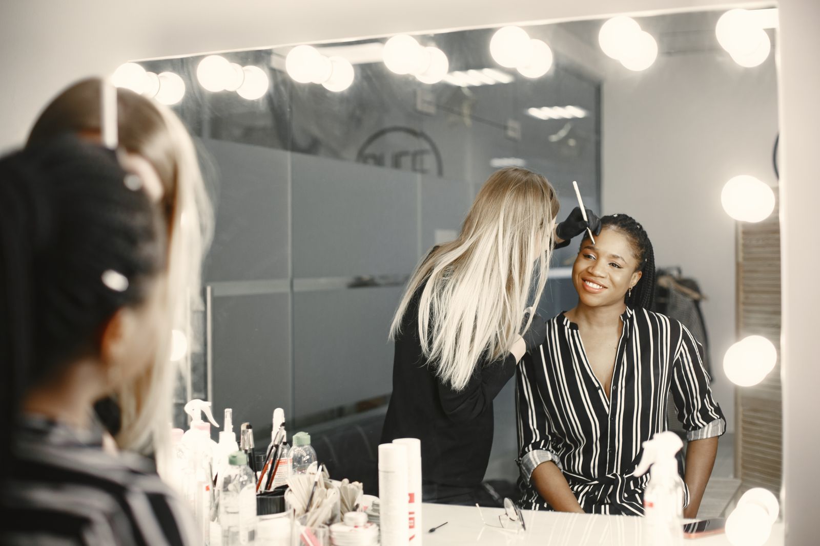 Makeup artist preparing a client in a bright studio